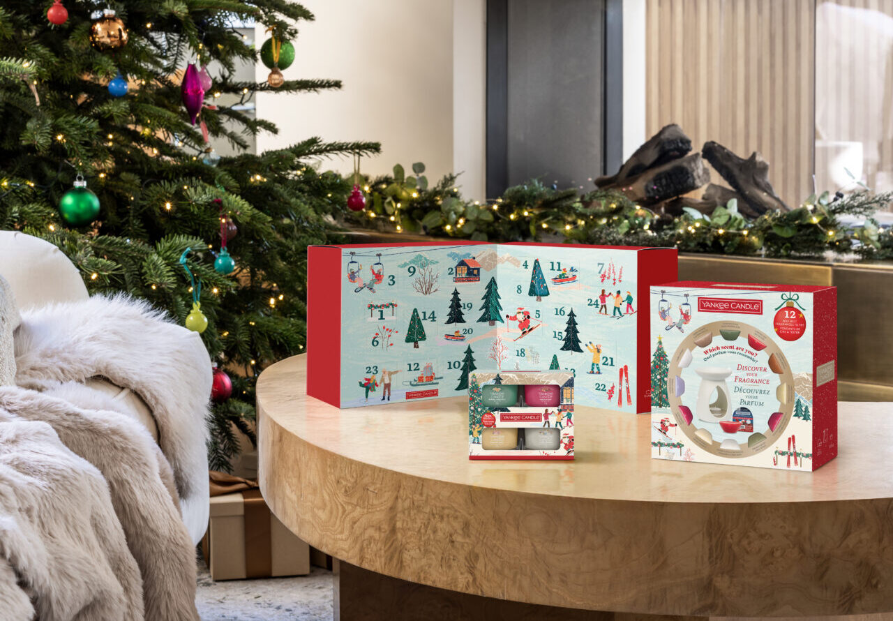 Juldekorationer och adventskalender vid en pyntad gran och öppen spis.